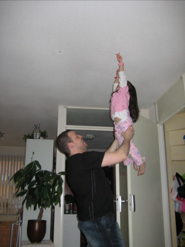 Yana's dad holding baby Yana in the air